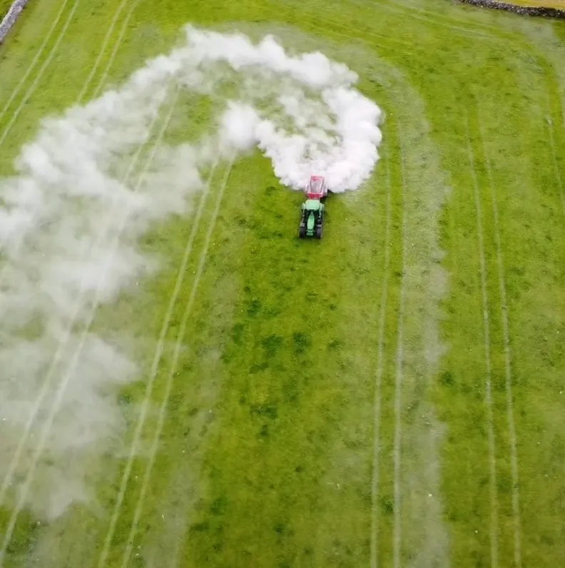 Drone view of a tractor spraying a field